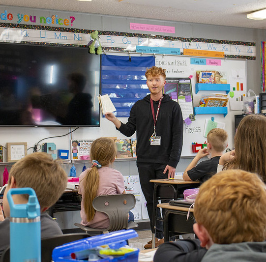 An elementary teacher in a classroom with students