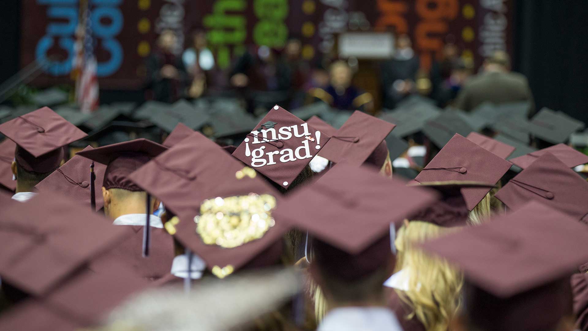 View of decorated mortar boards at a Missouri State University graduation ceremony. 