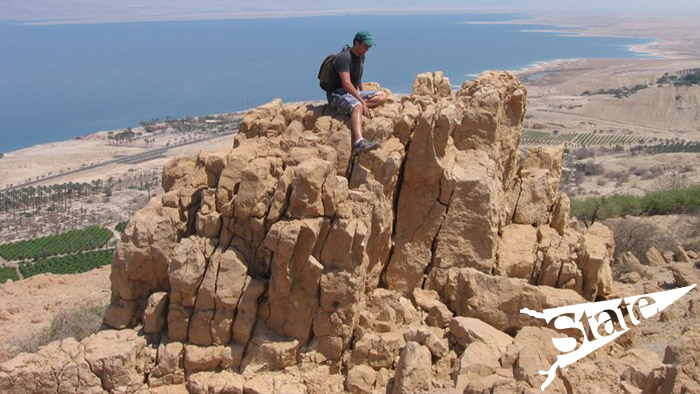 Lone rock climber sitting atop an outcropping.