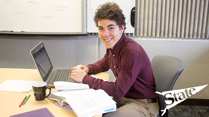 MSU student in a conference room using his laptop