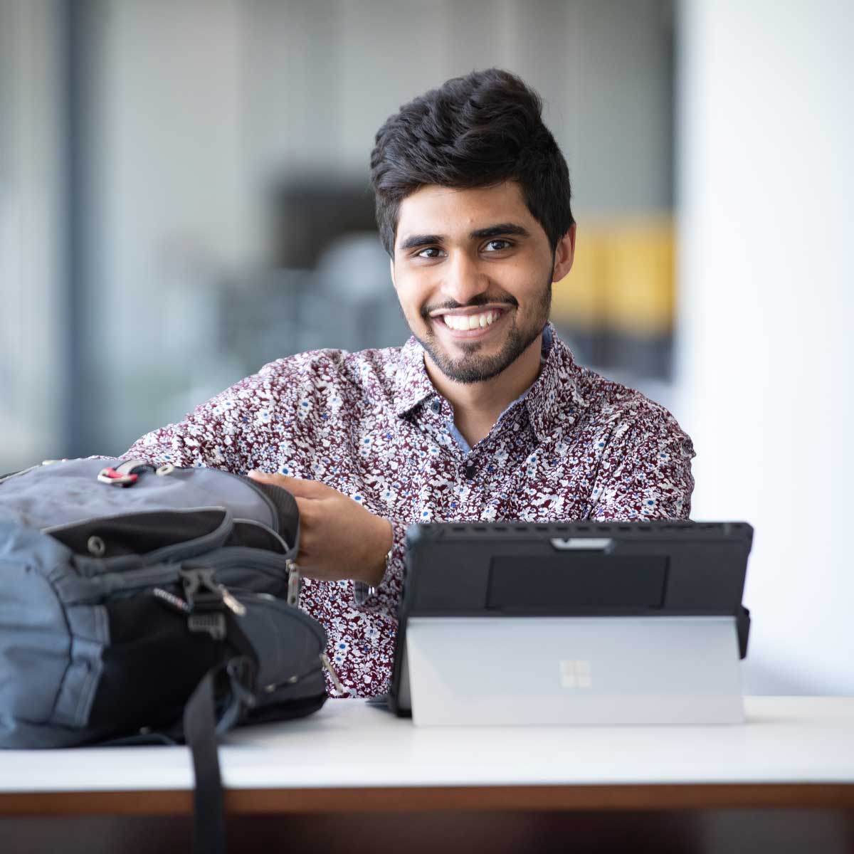 Young man sitting at a table with his tablet