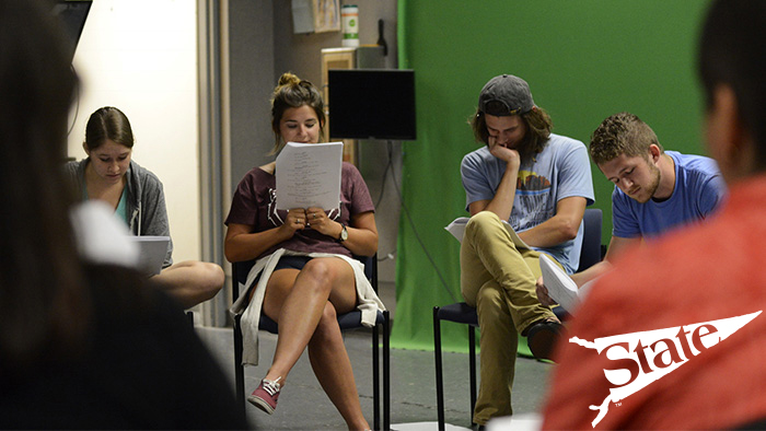 Screenwriting students participate in a table read of a script.